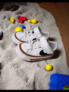 Nike Kids White Sneakers with Brown Trim and Black Swoosh Accent